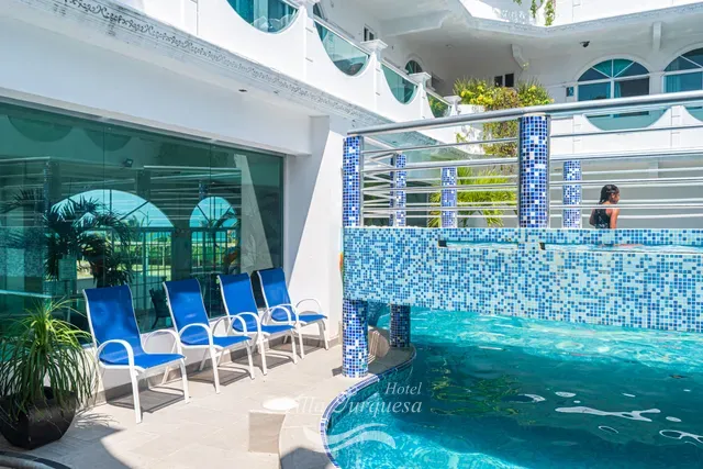 Camastros azules a la orilla de la alberca · Hotel Villa Turquesa