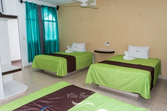 Tres camas matrimoniales en una habitación amplia · Hotel Villa Turquesa